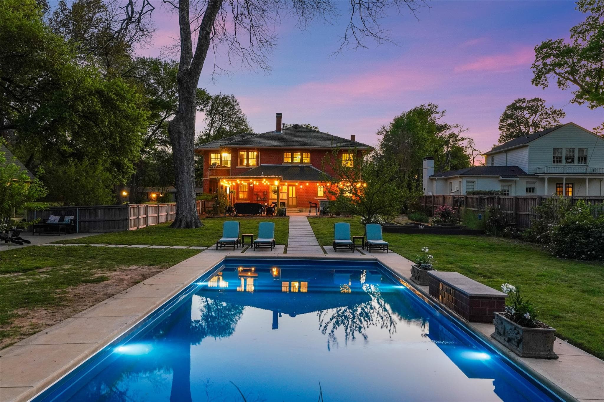 One of our listings photographed at dusk with a pool and illuminated home